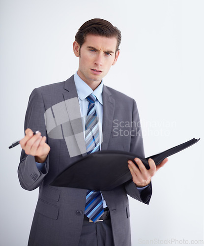 Image of Confused, portrait and man writing on paper documents in studio for compliance, complaint or discipline on white background. Face, hr and businessman with file for accountability or warning workplace