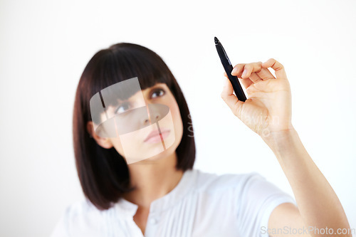 Image of Business woman, writing and thinking for schedule, planning or strategy against a white studio background. Serious female employee in brainstorming, project plan or tasks for ideas or reminder