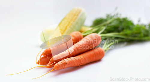 Image of Vegetable, carrot and corn as healthy food in studio with color, art and creativity for nutritionist. Cooking, wellness diet or nutrition with green or vegan ingredient isolated on a white background