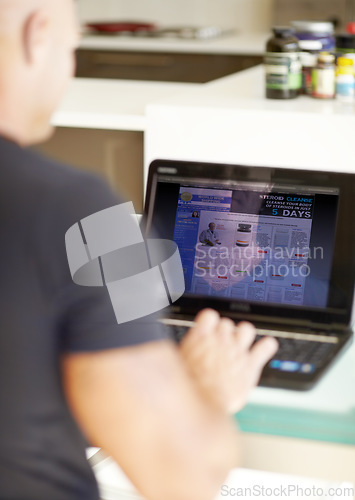 Image of Man, laptop screen and research on website product or supplements on kitchen table at home. Rear view of male person searching on computer for online information, browsing or pharmaceutical knowledge