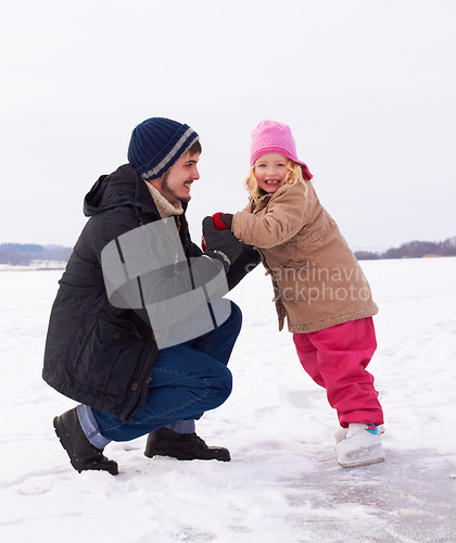 Image of Father with daughter outdoor, learn to ice skate and fun in nature with snow, winter and people skating on frozen lake. Man have fun with girl child, teaching and learning with sports and recreation