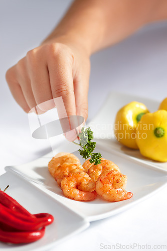 Image of Hand, prawn and a chef in a restaurant for food serving or luxury hospitality in hotel accommodation. Seafood, shrimp and cooking with a person plating a meal in the kitchen for hunger or nutrition