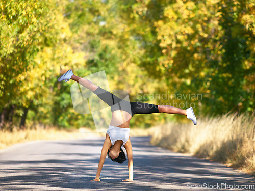 Image of Woman in street, cartwheel and fitness outdoor with energy, workout and gymnastics with active person. Female athlete, gymnast and exercise in nature, healthy with physical activity and sports