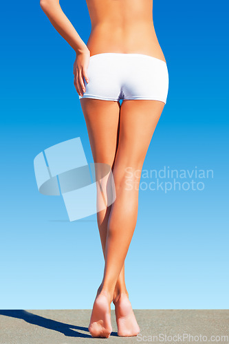 Image of Woman, legs and blue background with body, fitness and wellness from leg epilation. Sunshine, model and back of a person with underwear and rear view of butt and exercise figure with sky in summer