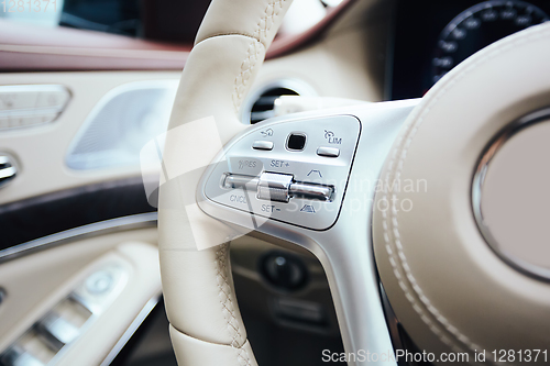 Image of Control buttons on steering wheel. Car interior.