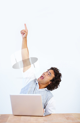 Image of Celebrate, laptop and businessman pointing up winning, celebrating and isolated in a white studio background. Office desk, winner and male employee or worker showing mockup due to achievement