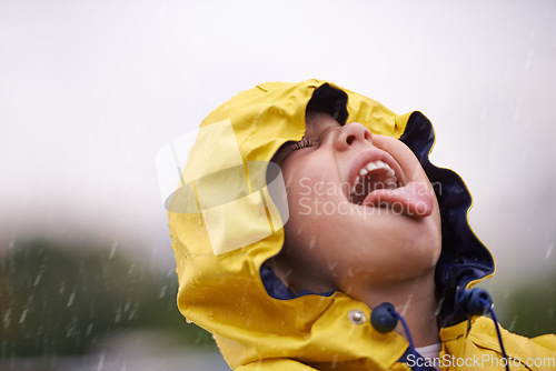 Image of Girl child, headshot and rain for playing, shouting and happiness in nature, outdoor and winter. Female kid, raincoat or playful with water, open mouth or taste on adventure with freedom in childhood