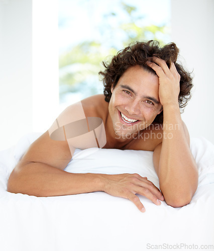 Image of Happy, portrait and a handsome man in bed for sleep, relaxing and content in the morning. Wake up, resting and a guy in the bedroom looking calm after sleeping, nap or rest in the comfort of a house