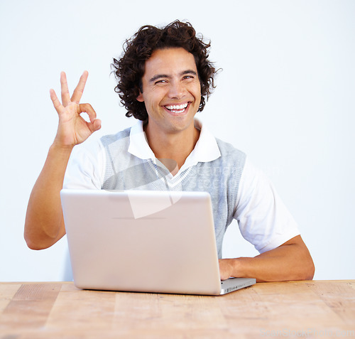 Image of Portrait, okay and laptop with a business man working at a desk in the office to finish a project. Smile, hand gesture and complete with a happy male employee at work on a computer in the workplace