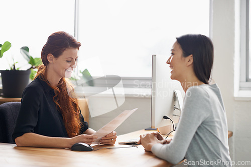 Image of Resume, job interview and business women in office in conversation, talking and discussion at desk. Communication, partnership and female workers with paperwork for recruitment, cv and hiring review