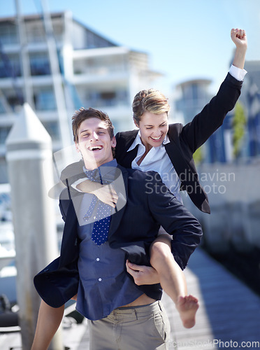 Image of Celebration, piggyback and corporate couple at harbor excited for success, startup or travel freedom. Business people, victory and man with woman before traveling in Amsterdam, winning and hand sign