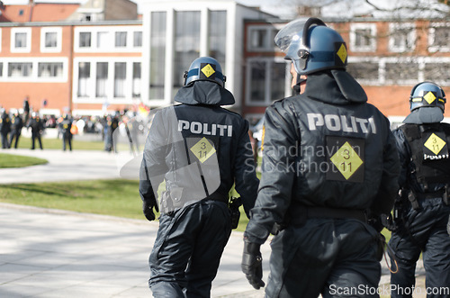 Image of Law enforcement, riot and protest with police officer in city for safety, protection or security. Brave, uniform and government with group of policeman in street for rally, human rights or activist