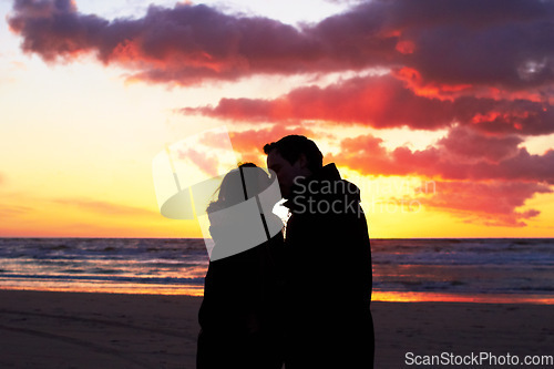 Image of Beach, sunset and couple silhouette kiss in nature with love, freedom and romance outdoors. Shadow, romantic and people kissing at sunrise, sweet and together for travel, vacation or holiday in Bali