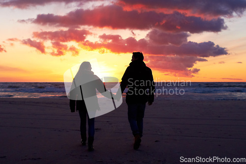 Image of Beach, silhouette and couple holding hands at sunset while walking, bonding and enjoying freedom. Love, shadow and man with woman at the ocean for travel, romance and sunrise walk on Hawaii vacation