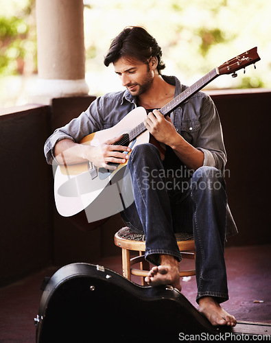 Image of Music, art and man playing guitar with musical talent for practice for a performance or concert. Performer, outdoor and male musician, guitarist or artist performing a song on a string instrument.