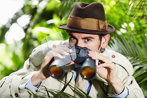 Image of Detective man, search and portrait in jungle with vintage gear for investigation and solution. Outdoor, private investigator and spy with binoculars for surveillance and retro reporter character