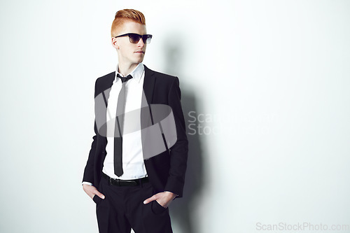 Image of Fashion, suit and mockup with a man in studio on a white background for formal or contemporary style. Thinking, sunglasses and confident with a handsome young male person standing hands in pockets