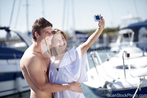 Image of Camera, selfie and couple hug, smile and pose at harbor for travel, honeymoon or trip together. Love, picture and traveling influencer people embrace for photo before cruise ship, vacation or holiday