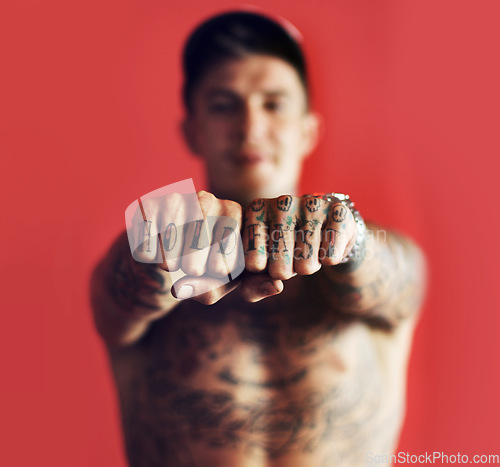 Image of Fist, tattoo or blurred man in studio isolated on red background with unique, cool or artistic creativity. Zoom, rebel or portrait of trendy macho person showing hands or knuckles with ink or tattoos