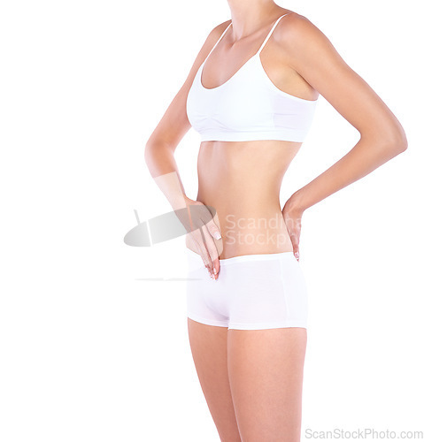 Image of Woman, flat stomach and hands in studio with waist, measuring or fitness for wellness by white background. Isolated model, girl and underwear with touching, body or abdomen for healthy lifestyle