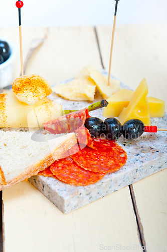 Image of mix cold cut on a stone with fresh pears