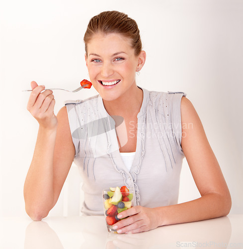 Image of Woman, portrait and fruit salad in a studio with happiness from healthy breakfast and food. Smile, young female person and diet nutrition of a model with organic eating for wellness and health