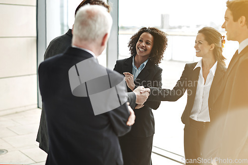 Image of Professional, handshake and group for negotiation at work with a smile to show support for collaboration. Business, people and agreement at the lobby for contract with success at a corporate office.