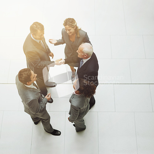 Image of Top view, handshake and group of business people in meeting for deal, agreement or crm on mockup. Above, shaking hands and employees with b2b collaboration, partnership and welcome to company office.