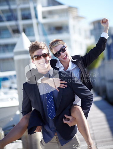 Image of Piggyback, celebration and couple at harbor excited for success, startup and travel freedom. Business people, victory and cheerful man with woman before traveling in Amsterdam, winning and hand sign