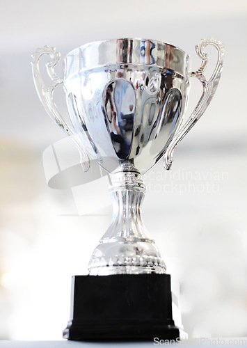 Image of Trophy, reward and celebration award as an achievement for winning a silver prize due to success of a champion. Shine, cup and victory championship with value for a winner in a competition