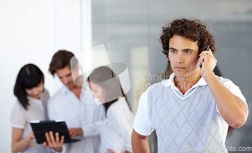 Image of Phone call, office and business man with team in serious conversation, discussion and networking. Communication, corporate and male worker on cellphone talking, speaking and connection in workplace