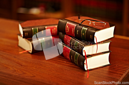 Image of Legal books, glasses and lawyer research textbook in a student library with no people. Justice, knowledge and judge book for investigation and attorney work in archive and university law department