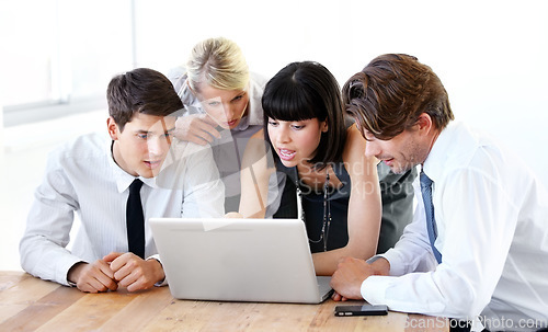 Image of Collaboration, laptop or research with a business team in the boardroom, working together on a project. Teamwork, planning or strategy with men and women employees at work in the office on a computer