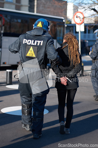 Image of Police man arrest woman at protest in city, crime and law enforcement, security at demonstration in the street. Public servant, service and patrol for safety at event, activist and officer back view