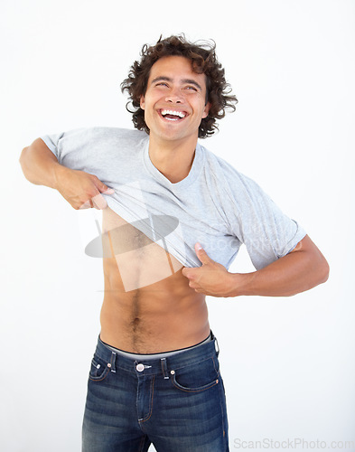 Image of Happy, laughing and a man dressing in studio on a gray background while changing clothes for summer. Smile, funny or clothing with a handsome young male person getting ready in a jeans and t-shirt