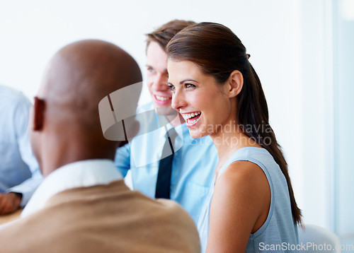 Image of Businesswoman, laugh and team in a meeting in the office in discussion and speaking about a funny joke. Collaboration, teamwork and professional employees working on company project in the workplace.