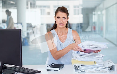 Image of Portrait, stress and pile of documents with a business woman in her office and looking worried about a deadline. Paper, report and backlog with a young female employee feeling overwhelmed at her desk