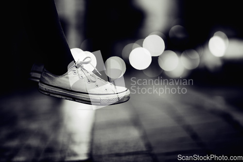 Image of Closeup, monochrome and sneakers outdoor, city and lights with creativity, road and artistic. Zoom, person or model with shoes, street and grey with footwear, night or creative with fashion or travel