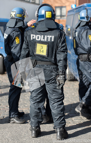 Image of Safety, crowd control and protest with police officer in city for riot, protection or security. Brave, uniform and government with person in Denmark street for rally, human rights or activist