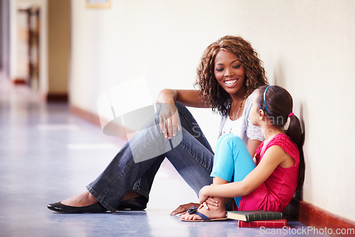 Image of Teacher, student and talking or conversation at school for support, trust or education. Happy black woman working at school for child discussion about bullying, learning and development in hallway