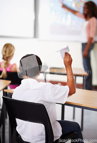 Image of Student, paper plane and classroom with teacher and children, learning at desks or young boy, distraction and play with origami airplane. Naughty kid, holding jet and middle school education
