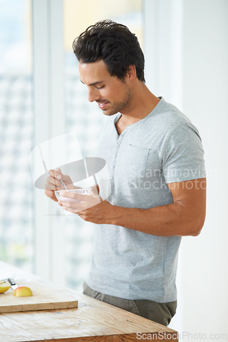 Image of Health, diet and man eating a fruit salad for breakfast, lunch or a healthy meal in his kitchen. Nutrition, wellness and male person enjoying a organic, natural and vitality food in his modern house.