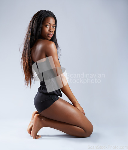 Image of African woman, studio floor and lingerie in portrait, kneeling or beauty for sexy aesthetic by white background. Isolated girl, model or sitting for clothes, underwear or alluring fashion by backdrop