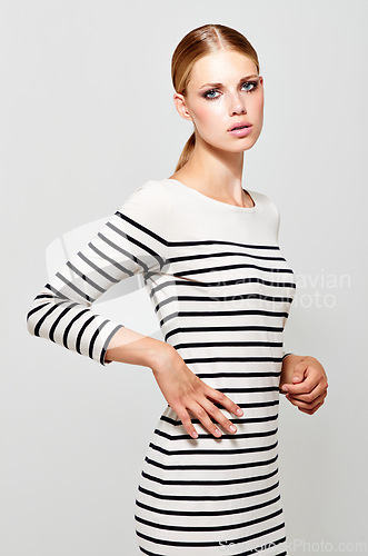 Image of Woman, dress stripes and fashion portrait with designer style in a studio. Isolated, white background and young female model with confidence and stylish youth wearing cosmetics and luxury dress