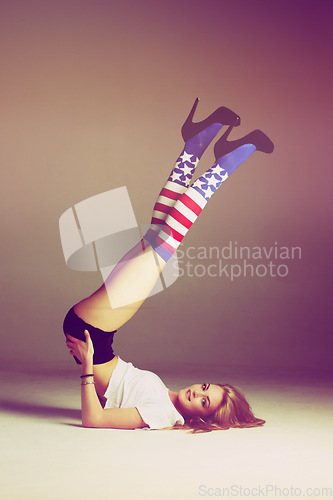 Image of Woman, usa fashion and portrait of a model with flag socks and legs in air in studio. Isolated, female person and gen z clothes with youth and body posing with a smile and patriotic aesthetic