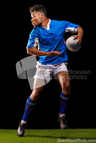 Image of Rugby, night and man sports athlete running in dark studio background while training, wellness and fitness. Exercise, workout and professional career of sport male person or player on grass