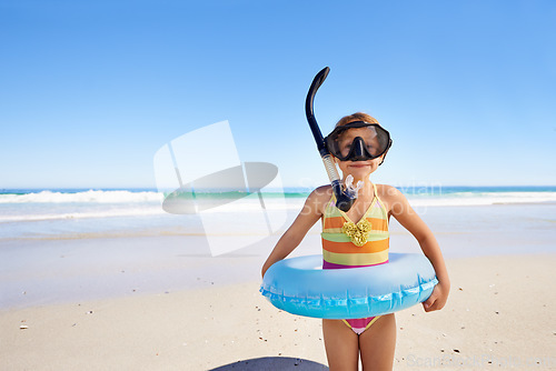 Image of Beach, fun and girl child with swimming inflatable, snorkel and excited against ocean background. Adventure, portrait and kid at the sea with a swim ring for exploring, playing and vacation in Bali