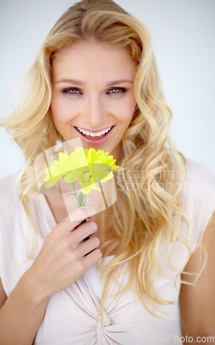 Image of Portrait of happy woman, daisy and flowers in studio, isolated and white background. Female model smile with yellow plant, petals and fresh blossom for happiness, sustainability and floral beauty