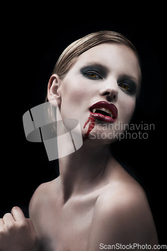 Image of Portrait, woman and vampire with blood, lady and bare against a dark studio background. Face, female character and girl with fantasy, makeup and cosmetics with cosplay, person and supernatural being