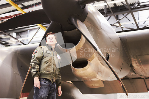 Image of Army, jet and man pilot or combat plane or low angle in front of propeller and in navy uniform on tarmac. Military, jet fighter and in hangar or soldier in training gear and aircraft for mission